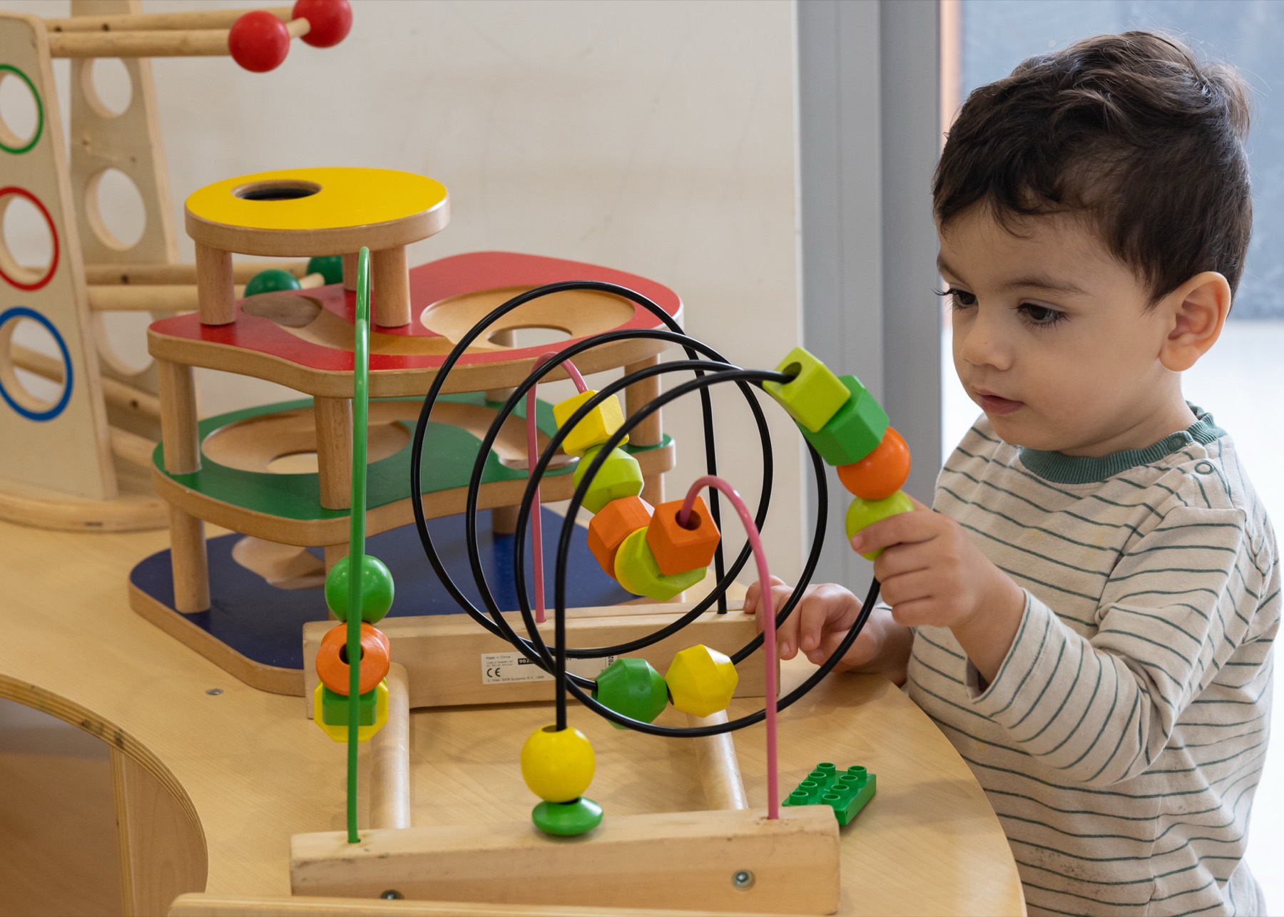 A child concentrating on a bead maze